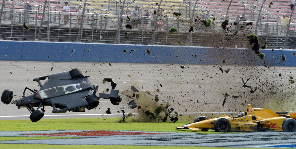 AP photo 
 Ryan Briscoe flips through the infield grass in front of Ryan Hunter-Reay on Saturday  during the IndyCar auto race at Auto Club Speedway in Fontana, Calif.