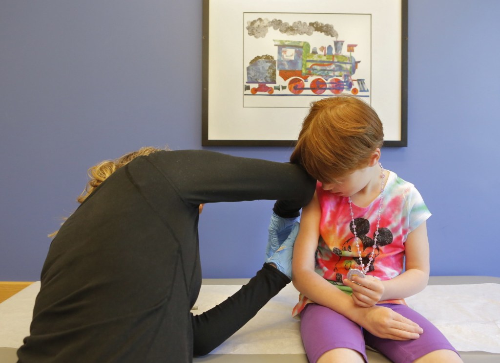 Kiara Boisvert, 5, gets a varicella booster vaccination Thursday from Amy Moran, a clinical assistant at Intermed in South Portland. Photo by Gregory Rec/Staff Photographer