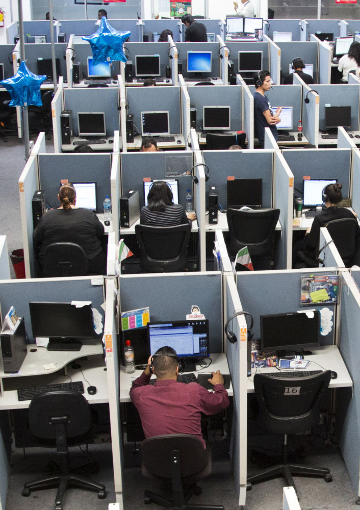 Workers sit at desks at Firstkontact Center, a call center in Tijuana, Mexico.