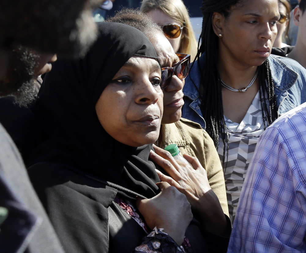 Rahimah Rahim, left, mother of shooting victim Usaama Rahim, listens during a news conference Thursday in Boston’s Roslindale neighborhood in the area where Rahim was shot to death.