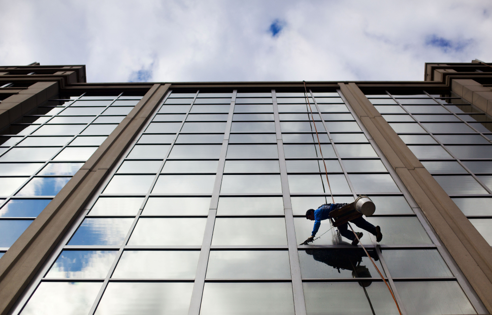 A window washer cleans the windows of an office building in downtown Washington. Friday’s solid jobs report confirms the economy’s vitality.