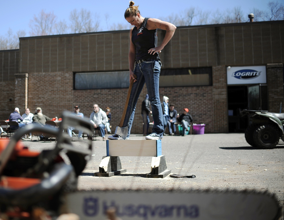 In this Saturday, April 25, 2015 photo, Alissa Harper, founder of Axe Women of Maine, pauses before chopping a block of wood during a demonstration in Vernon, Conn. Harper, of Bar Harbor, Maine, started Axe Women in 2010. Group members hold six world titles in various women lumberjack competitions.