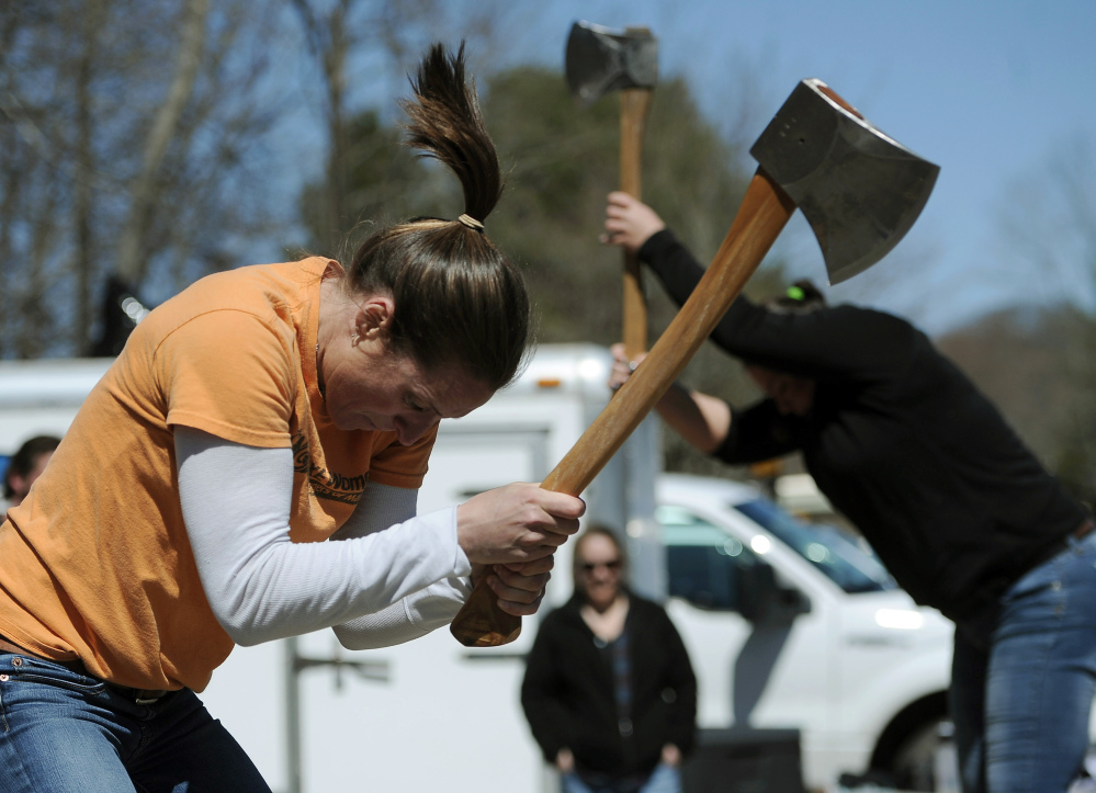 In this Saturday, April 25, 2015 photo, Alissa Harper, left, and Michele Watkins chop blocks of wood during the Axe Women of Maine’s demonstration in Vernon, Conn.