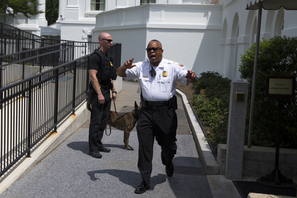 Secret Service police move members of the media outside the briefing room as they evacuate parts of the White House in Washington on Tuesday.