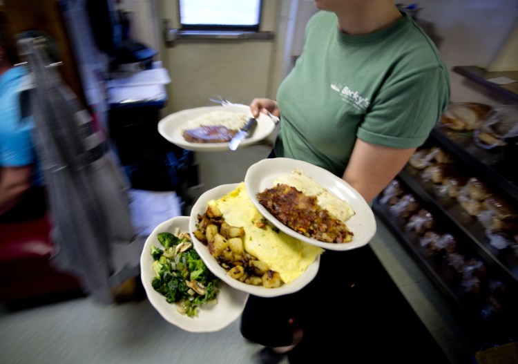 Laura Applin, a waitress at Becky’s Diner in Portland, carries plates mostly filled with eggs prepared in some fashion to customers Tuesday morning. Becky’s goes through as many as 1,500 eggs daily.