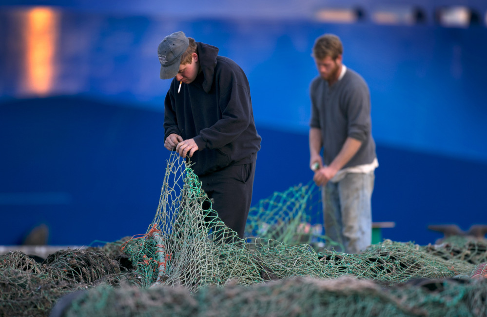 2013 Associated Press File Photo/Robert F. Bukaty
Fishermen mend groundfishing nets in Portland. Regulators’ recent changes to habitat affect the way fishermen catch important species including cod and scallops in federal waters from Maine to Rhode Island.