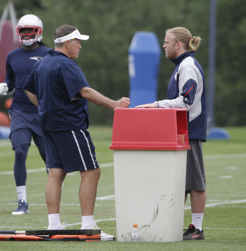 New England Patriots head coach Bill Belichick, left, speaks with his son, coaching assistant Steve Belichick, during an NFL football minicamp Tuesday in Foxborough, Mass. 