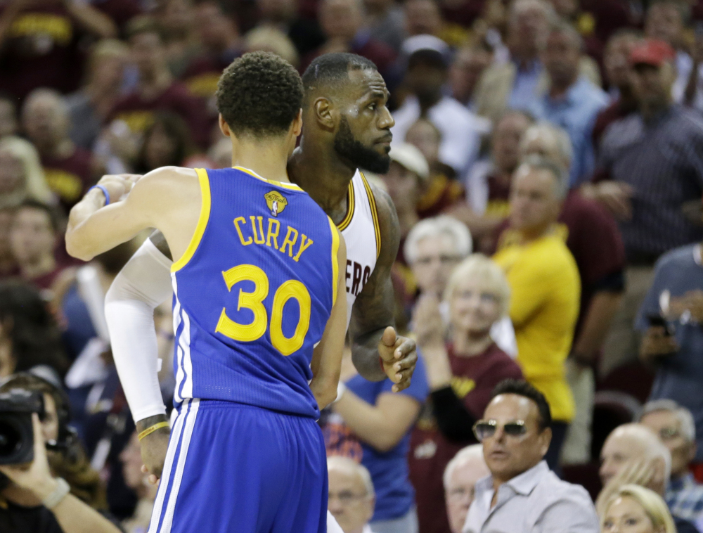 Warriors guard Stephen Curry hugs LeBron James as Game 6 winds down Tuesday night in Cleveland. The Warriors defeated the shorthanded Cavaliers, 105-97, to win the best-of-seven game series 4-2.