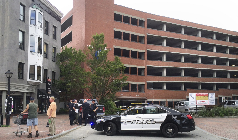 Police cars block the entrance to the One City Center parking garage in Portland on Friday afternoon. An man armed with a pistol robbed the Bank of America branch at One City Center and reportedly fled toward the garage. Police did not find the man in the garage. Gregory Rec/Staff Photographer