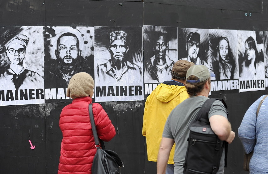 A group of eight portraits that first appeared last month on a black plywood wall next to Congress Street have become part of the citywide conversation about whether Portland should continue providing aid to asylum seekers. The black-and-white portraits show eight men and women of different ethnic backgrounds, each labeled “Mainer.” The portraits bear the signature of Pigeon, a street artist.