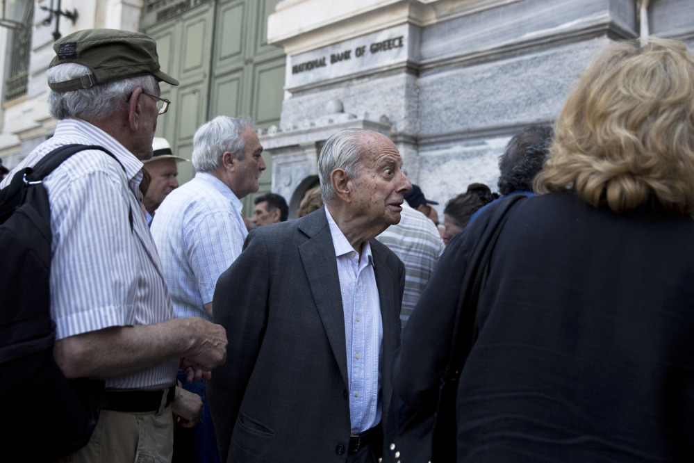 A pensioner is told by an employee Monday that he is not going to receive his pension after waiting for hours outside the national bank of Greece in Athens. 
The Associated Press