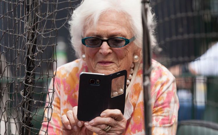 Former first lady Barbara Bush takes photos with her cellphone before  a Houston Astros game in Houston in this May 3, 2015, photo. The Associated Press