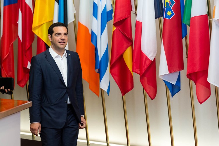 Greek Prime Minister Alexis Tsipras walks in front of European flags after a meeting with European Commission President Jean-Claude Juncker on the sidelines of the EU meetings in Brussels on Thursday. Tsipras continued his diplomatic offensive, meeting with EU ministers as Greece strives to avoid bankruptcy.
The Associated Press