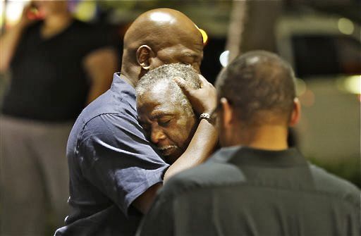 Worshippers embrace following a group prayer across the street from the scene of a shooting Wednesday, at Emanuel AME Church in Charleston, S.C. The Associated Press