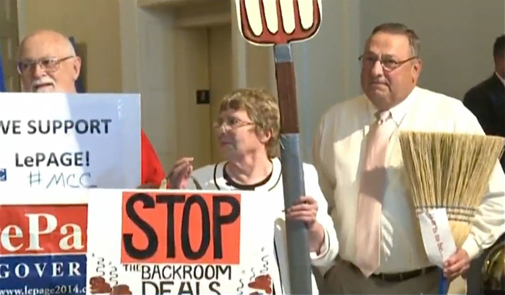 Gov. Paul LePage holds a broom during a rally of about 50 people who supported the governor's veto of the $6.7 billion state budget. The governor said the broom represented his conviction that he had been re-elected to clean up in Augusta. Screen image from WCSH-TV video