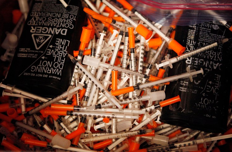 Used hypodermic needles are seen in a bin Thursday, July 2, at the India Street Public Health Center Needle Exchange in Portland, Maine. Joel Page/Staff Photographer