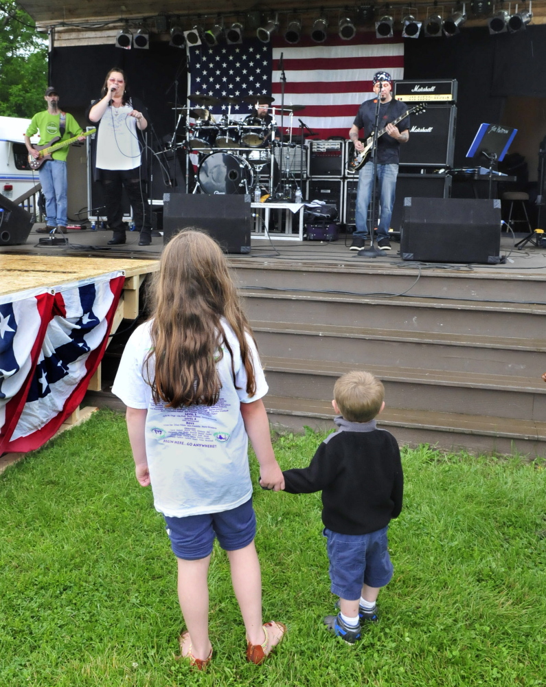 Taylor Denis, left, and Blake Whitman watch Right Amount of Wrong perform Wednesday at Fort Halifax Park in Winslow on the opening day of the Winslow Family 4th of July.