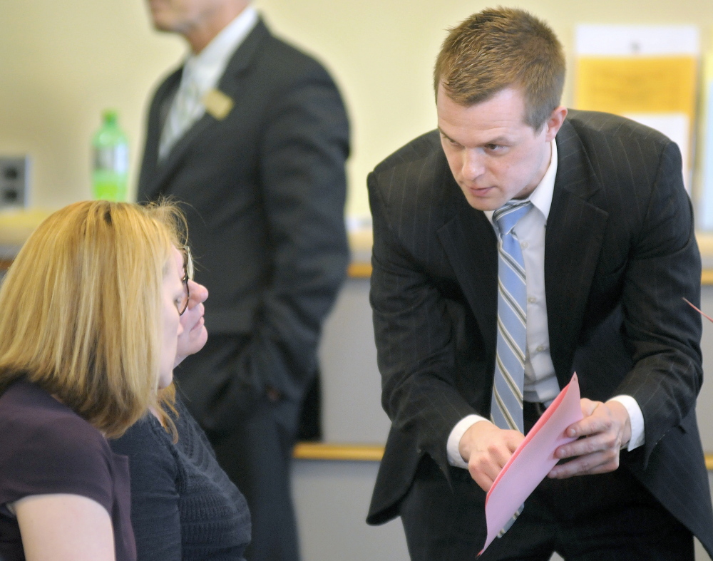 Volunteers of America vice presidents Melissa Morrill, left, and Julia Wilcock speak with Rep. Jared Golden, D-Lewiston, in this April file photo. Two pieces of legislation sponsored by Golden to help build housing for homeless veterans have been held over until the next legislative session.