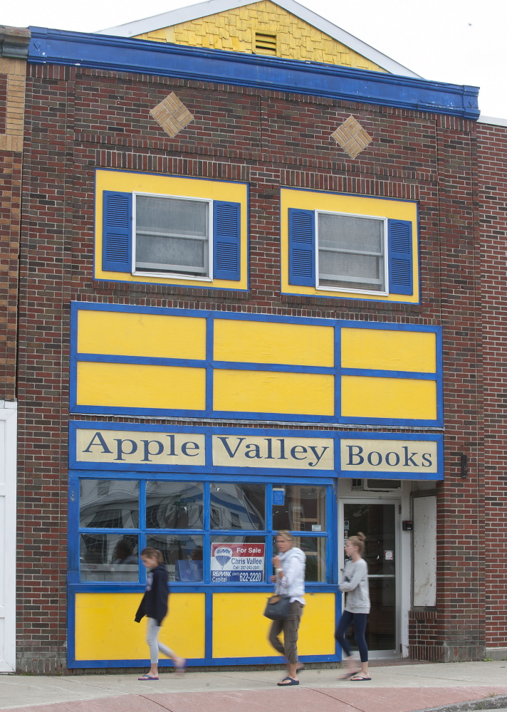Pedestrians walk past the now-closed Apple Valley Books on Monday in Winthrop.