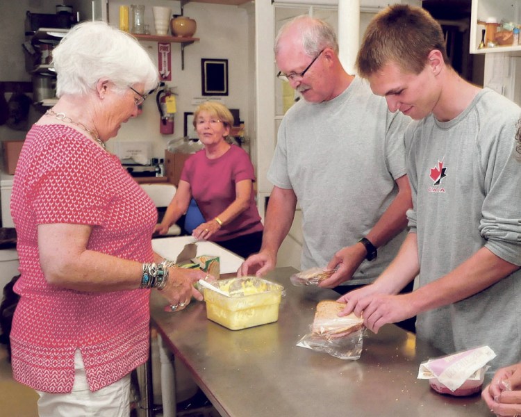 Evening Sandwich Program summer Directors Sue Morrill, left, and Connie and Ray Winship help volunteer Jimmy Fowler make sandwiches at the Universalist Unitarian Church in Waterville recently.