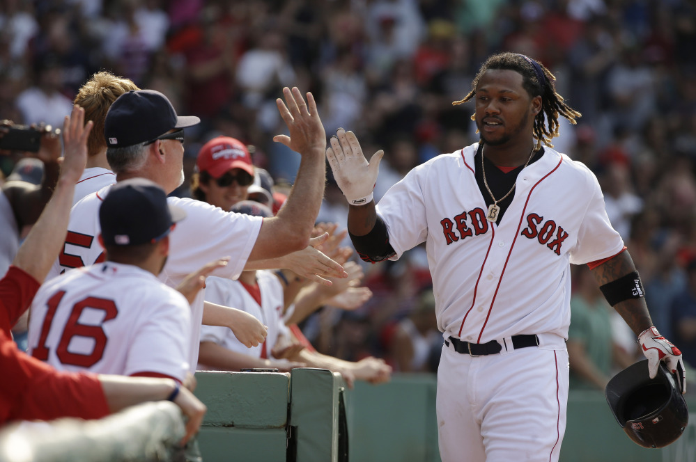 Boston’s Hanley Ramirez is welcomed to the dugout after hitting a two-run home run in the seventh inning against the Houston Astros on Sunday at Fenway Park in Boston.