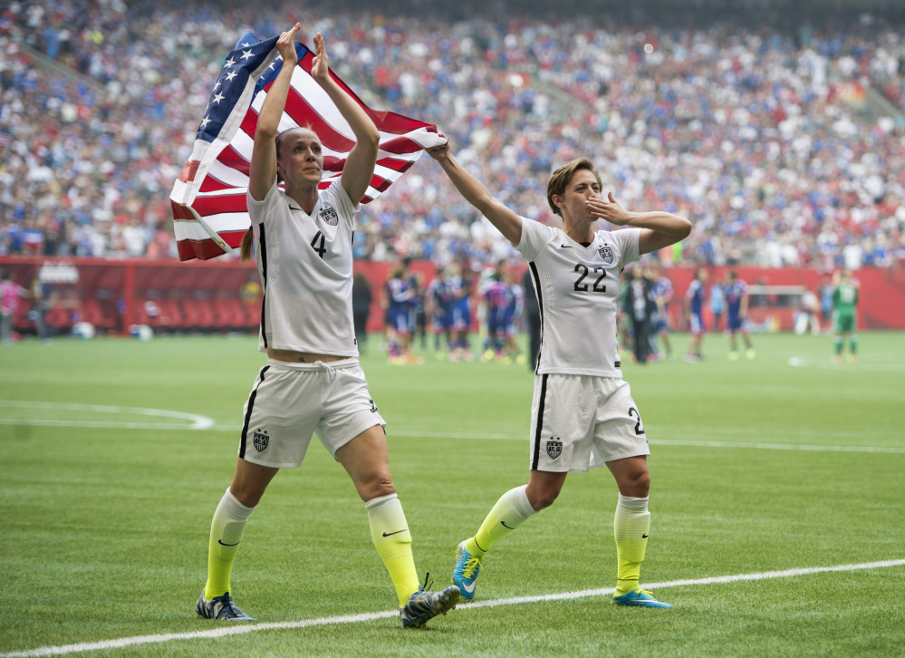 AP photo
USA teammates Becky Sauerbrunn, left, and Meghan Klingenberg celebrate following their championship win over Japan at the FIFA Women’s World Cup on Sunday in Vancouver, British Columbia, Canada.
