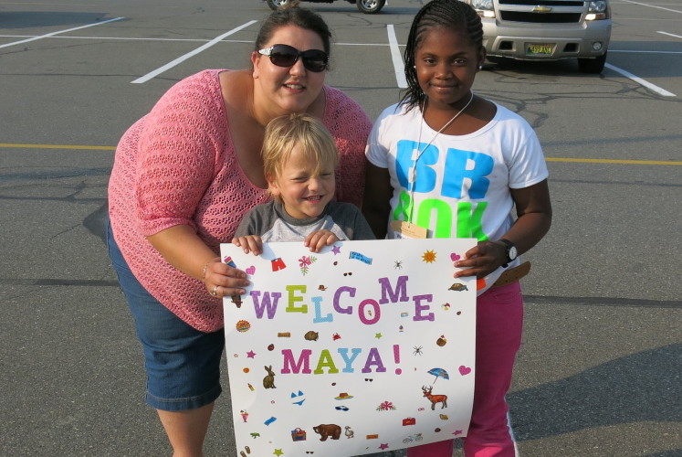 Megan Cyr, of Brooks, and her son Aidin welcome Maya on Monday as 20 children from New York City arrived for the annual Fresh Air Fund visit to central Maine.
