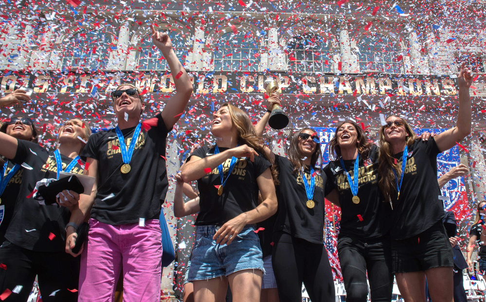 In a flurry of confetti, Abby Wambach, third from left, gestures to the crowd, surrounded by her teammates during a celebration for the U.S. Women’s World Cup soccer champions at New York’s City Hall, following their ticker tape parade up Broadway’s Canyon of Heroes on Friday.