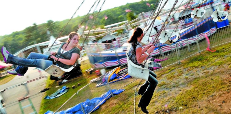 Krista Rogers, 19, left, and Megan Miville, 19, both of Fairfield, spin around on the Trapeze Swings in 2014 at the Skowhegan State Fair.
