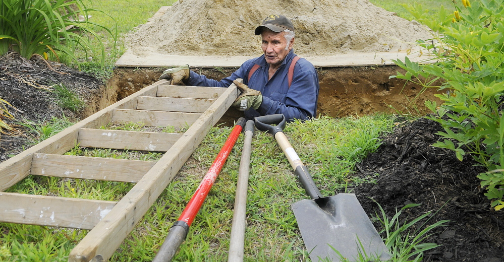 Litchfield Plains Cemetery caretaker Donald Vannah climbs out of a grave he dug by hand Tuesday at the cemetery. Each plot takes up to five hours to excavate by hand, he said.