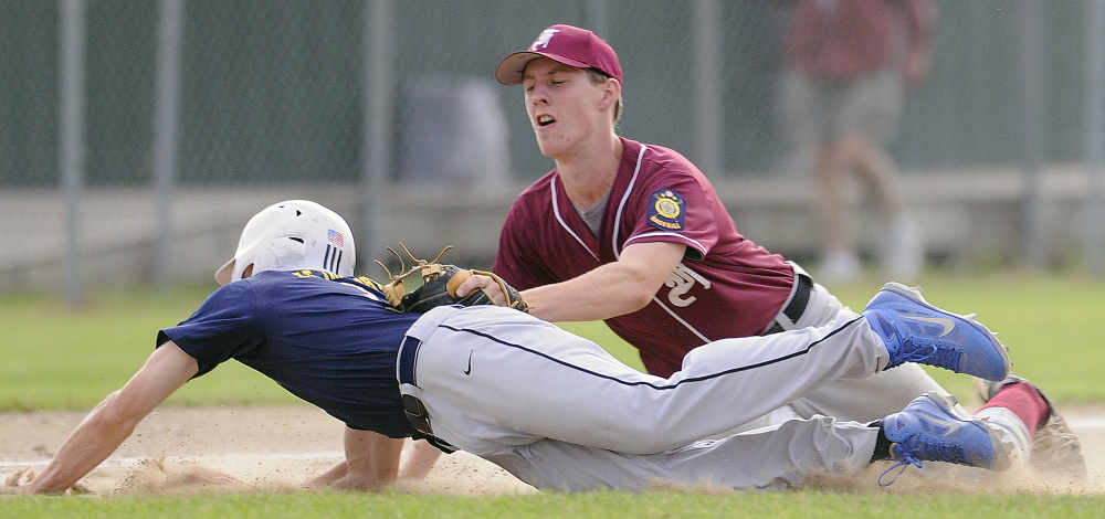 Staff photo by Travis Barrett 
 Augusta's Ryan Rodrigue gets tagged at third by Farmington's Evan Roberts during an American Legion game in Augusta last week.