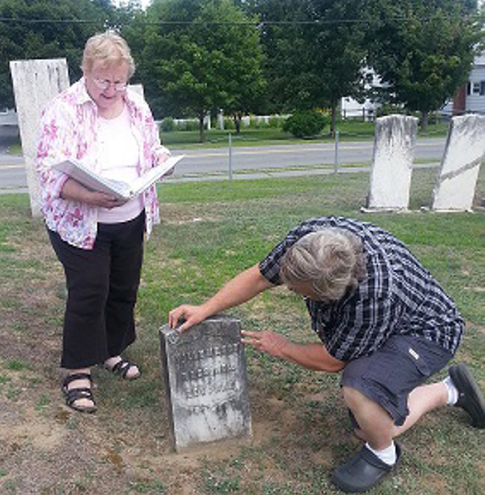 Guides Kay Marsh and David James examine the grave stone of Tilly Mason, Revolutionary Soldier at Southside Cemetery.