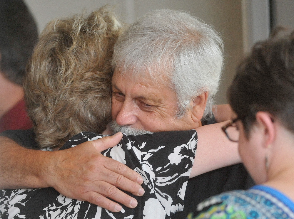 Jared Nightingale, husband of Karen Nightingale, is comforted by friends in July 2014 before his late wife’s memorial service at Lawrence High School in Fairfield.