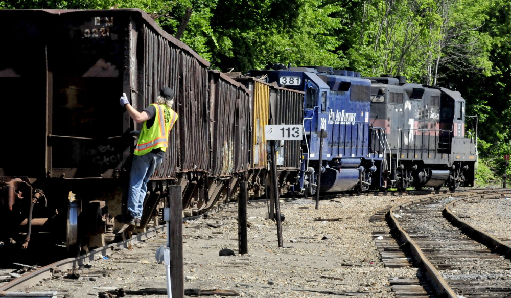 A Pan Am Railways worker rides the rear of a railroad car as an engineer pulls away at the Waterville yard on Wednesday The company has been fined $152,000 to settle allegations of environmental violations both in Waterville and Massachusetts.