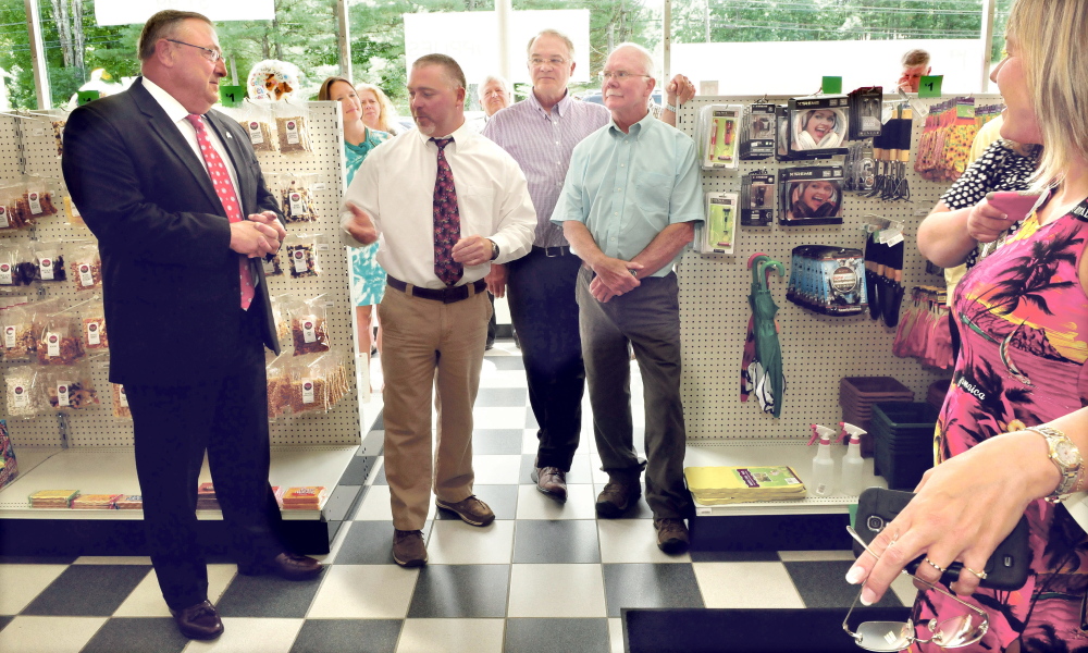 Oakland Pharmacy owner Shane Savage, center, speaks Thursday during a ribbon cutting ceremony for the relocation of his Oakland pharmacy. The event was attended by Gov. Paul LePage, left, his father Bud Savage, right, business partner Clay Smith and Kim Lindloff of the Mid-Maine Chamber of Commerce, among others.