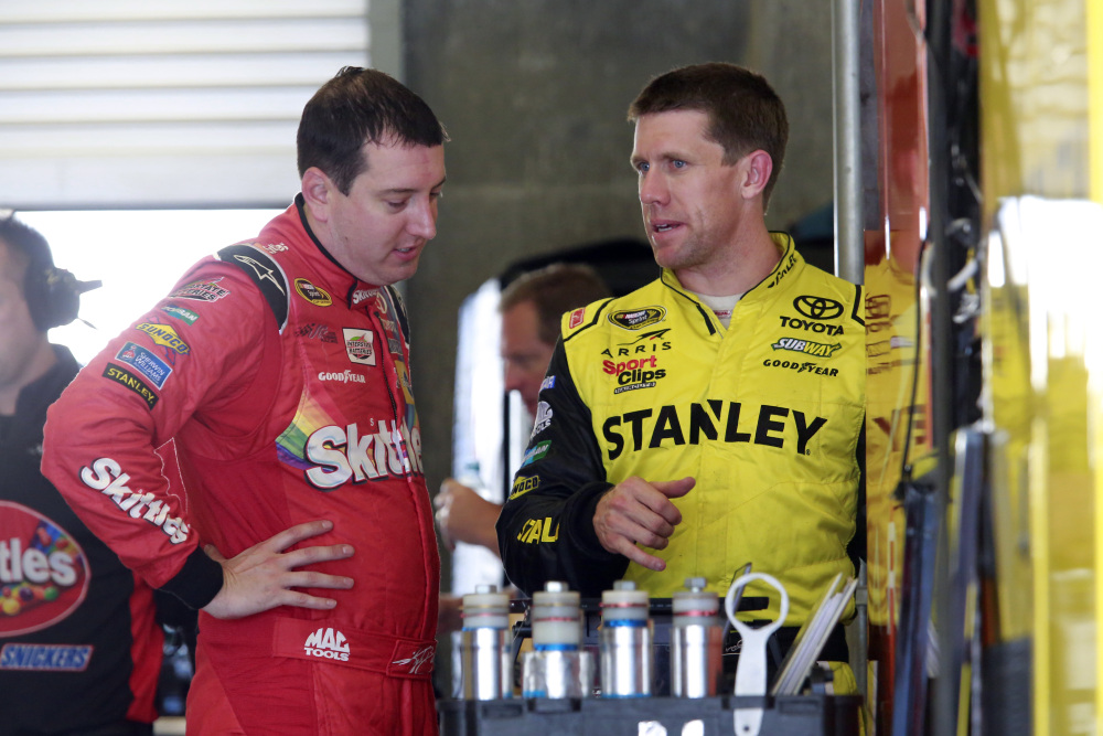 Kyle Busch, left, talks with Carl Edwards during practice Friday for the NASCAR Sprint Cup Brickyard 400 at Indianapolis Motor Speedway in Indianapolis.