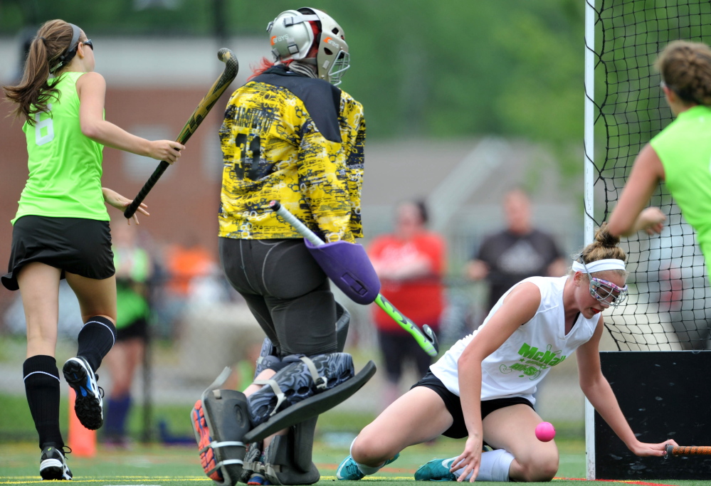 Staff photo by Michael G. Seamans 
 East players Meg Dowd, left, scores on West goalie Cassidy Smith (31)during the East/West all-star game Saturday at the Maine Field Hockey Festival at Thomas College.