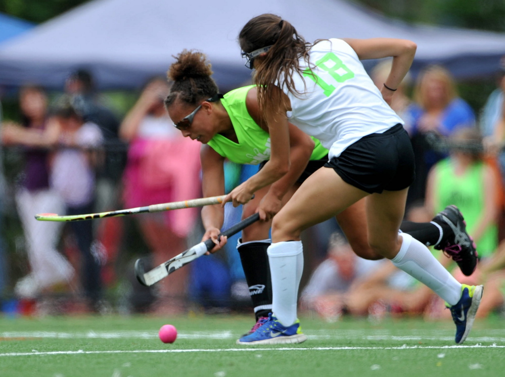 Staff photo by Michael G. Seamans 
 East player Victoria Newbill, left, battles for the ball with aa West defender during the East/West all-star game Saturday at the seventh annual Maine Field Hockey Festival at Thomas College.