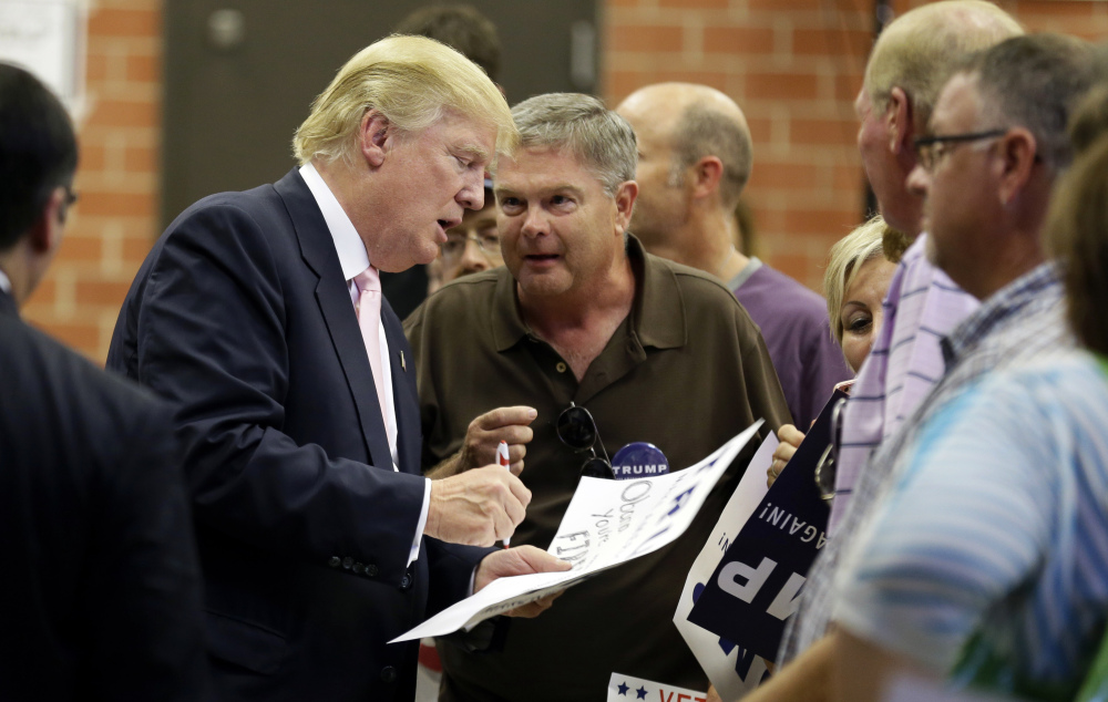 Republican presidential candidate Donald Trump signs autographs after speaking at a rally and picnic, Saturday in Oskaloosa, Iowa.