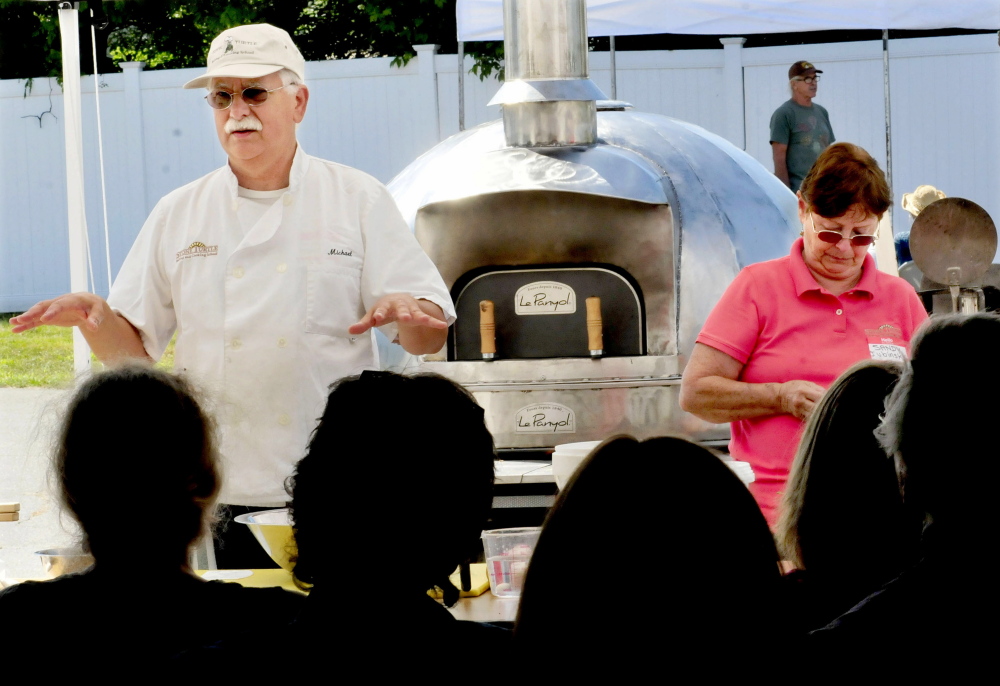 Michael Jubinsky explains the process of making bread in a wood-fired oven during a workshop in the 2013 Kneading Conference in Skowhegan as wife Sandy Jubinsky assists. This year’s conference, hosted by the Maine Grain Alliance, begins Thursday.