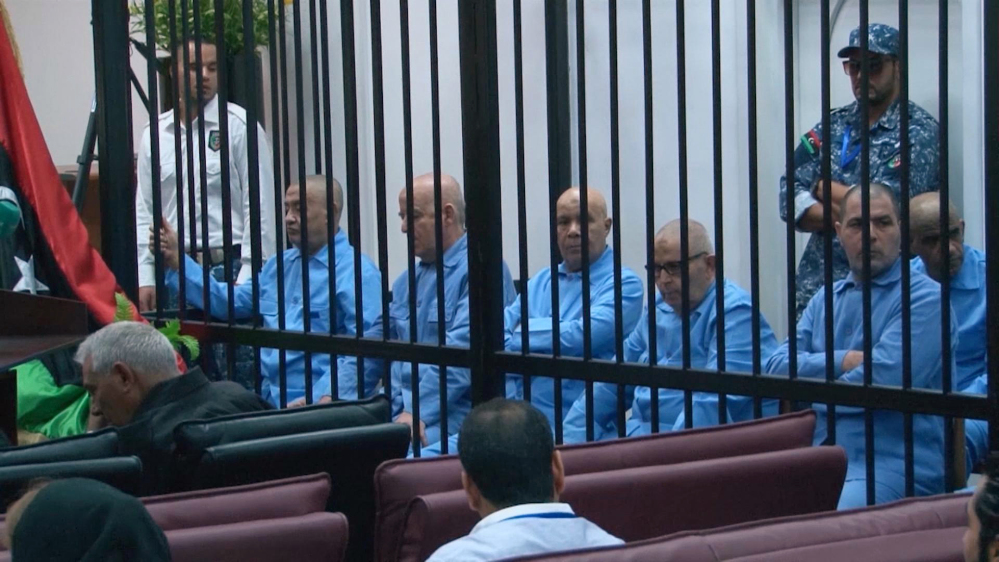 In this image made from AP video, former Libyan officials who served during Moammar Gadhafi’s era sit in the defendants’ cage during their trial for crimes committed during Libya’s 2011 uprising in a courtroom in Tripoli, Libya, Tuesday.
