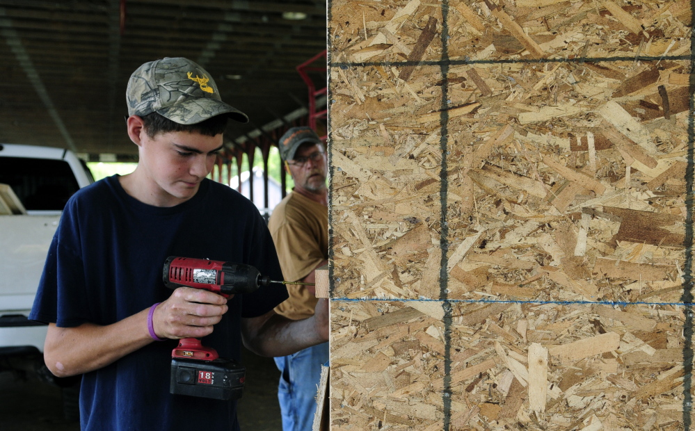 Brandon Kemp helps his father Jeff Kemp build a new ticket booth on Tuesday at the Monmouth Fair grounds.