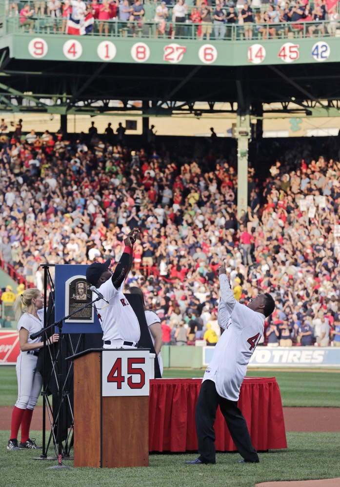 Baseball Hall of Fame member and former Boston Red Sox Pedro Martinez, right, and former teammate David Ortiz celebrate after Martinez’s No. 45 was unveiled on the facade of the right field grandstands during a ceremony prior to a game on Tuesday against the Chicago White Sox at Fenway Park in Boston.