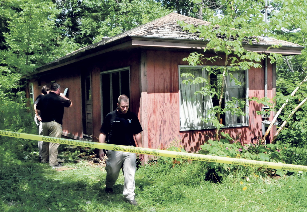 Winslow police officer Ronald McGowen leaves an abandoned camp on Whitefish Road in Winslow ahead of two investigators with the State Fire Marshal’s Office who are investigating a Thursday morning fire at the camp.