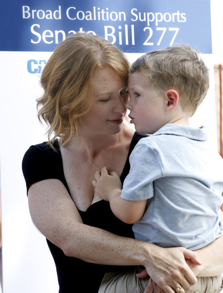 Jennifer Wonnacott, who supports a tough measure for California vaccinations, holds her son at a news conference in Sacramento on Tuesday.