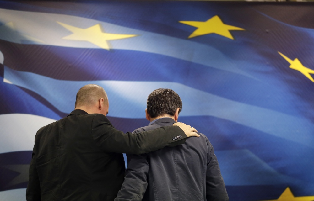 New Greek Finance Minister Euclid Tsakalotos, right, and outgoing Finance Minister Yanis Varoufakis leave together after a hand-over ceremony in Athens, on Monday. Greece is facing potential ejection from the eurozone.