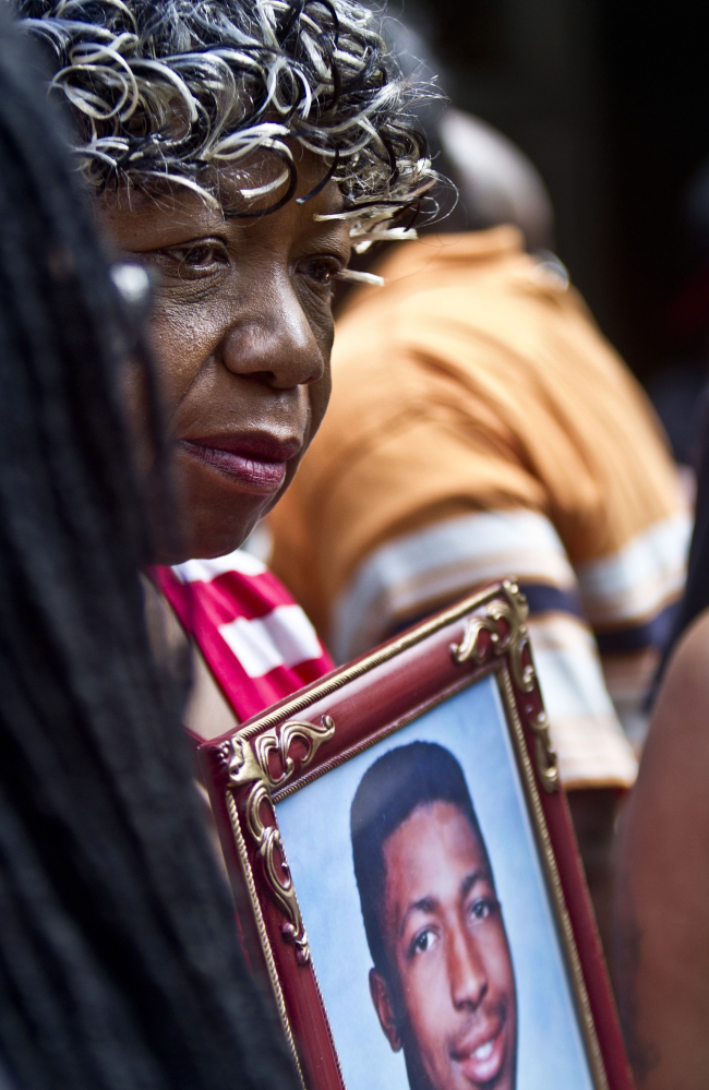 Gwen Carr holds a picture of her son Eric Garner during a news conference in New York on July 7 with relatives of New Yorkers killed by police. New York City reached a settlement Monday with the family of Garner for about $5.9 million, almost a year after Garner died in police custody.