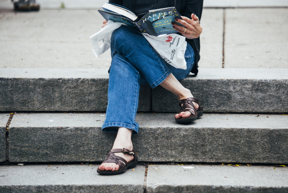 Pauline Domrad reads “Go Set a Watchman” in Congress Square Park. Colby College professor Cedric Bryant believes the novel will resonate today “if for no other reason than to suggest racism has a long shelf life.”