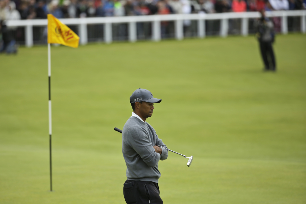 Tiger Woods walks on the 18th green Thursday during the first round of the British Open at St. Andrews, Scotland. Woods finished with a 4-over par 76, 11 shots off the lead.