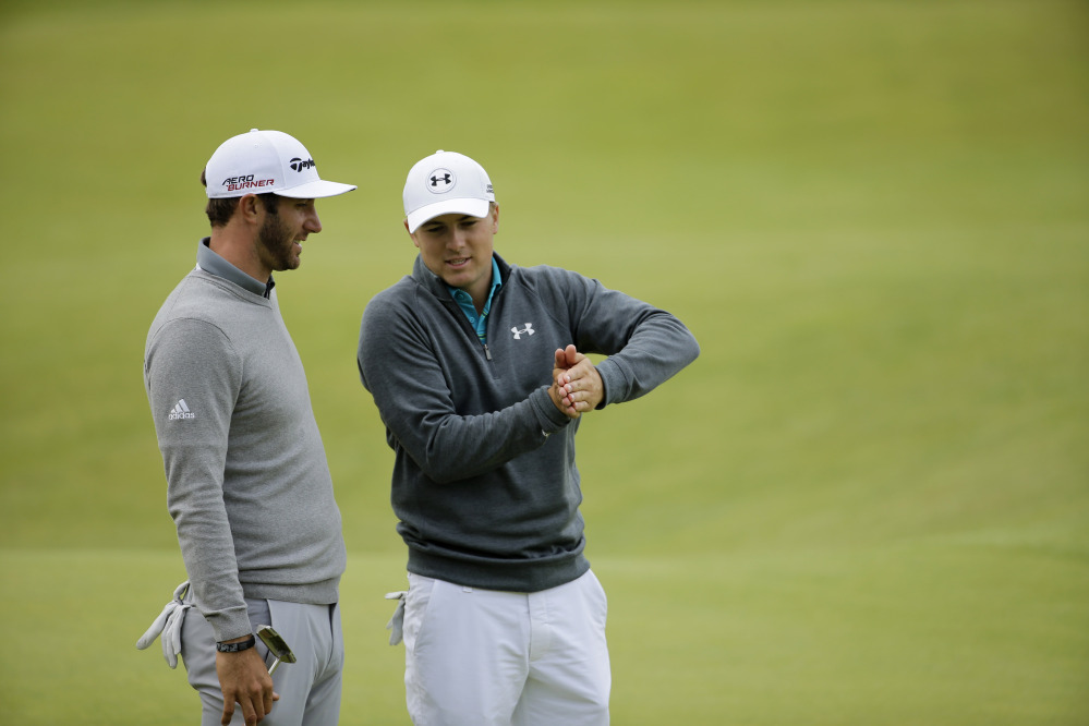 Jordan Spieth, right, and Dustin Johnson talk after finishing on the 18th green Thursday. Johnson, who shot a 65, swill take a one-shot lead into Friday’s round.